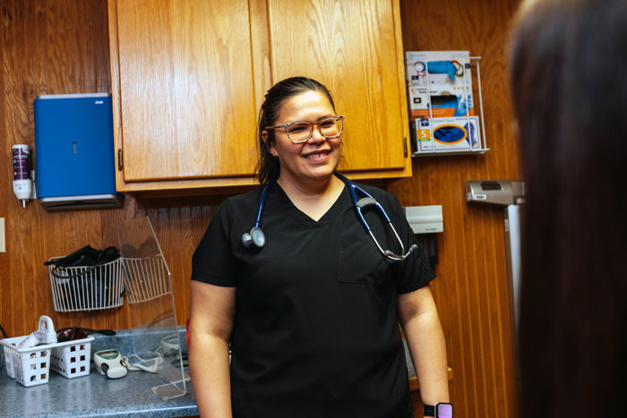 Barbour Health doctor smiling in patient's room.